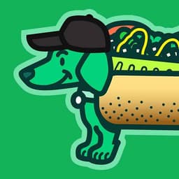 A smiling green wiener dog wears a Chicago Dog costume while wearing a black baseball cap.